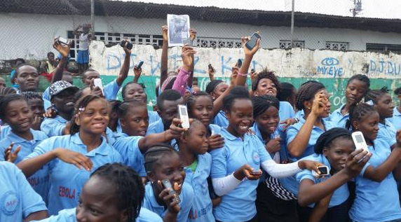 Liberian youths flash their mobile phones in support of UNICEF's U-Report (UNICEF Liberia)