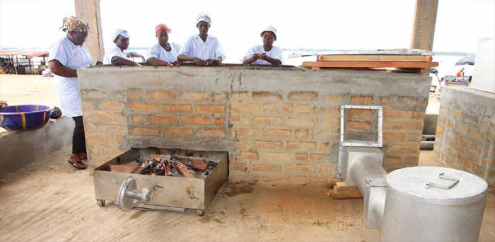Women in Abobodoumé, Côte d’Ivoire, huddle around the FAO-Thiaroye Processing Technique (FTT-Thiaroye) to smoke fish. Photo: FAO